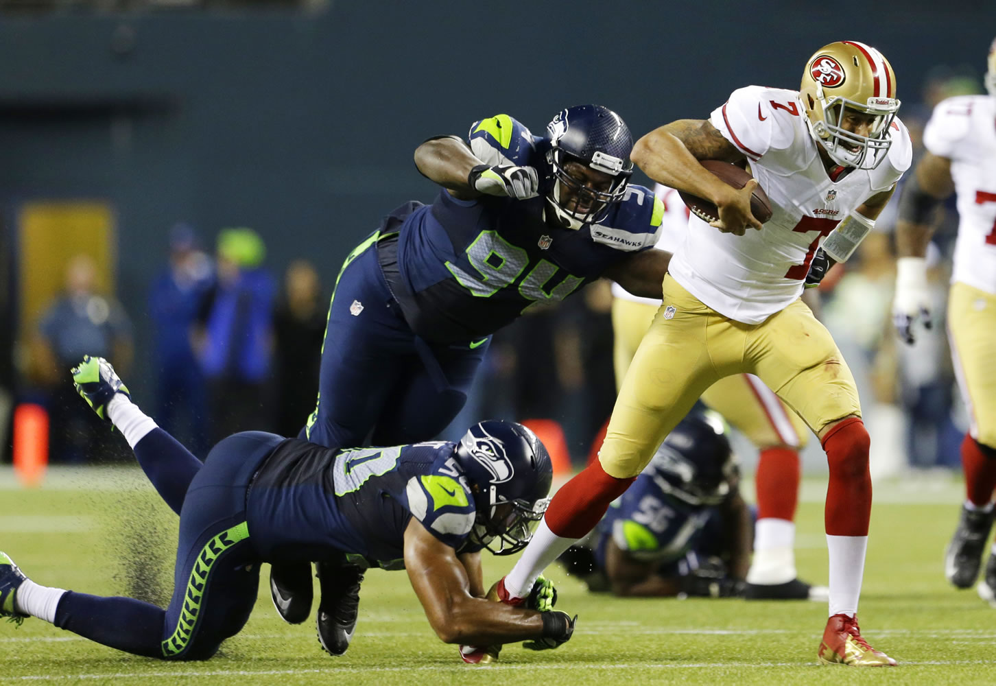Seattle Seahawks K.J. Wright, left, and D'Anthony Smith give chase to San Francisco 49ers quarterback Colin Kaepernick in the second half Sunday.
