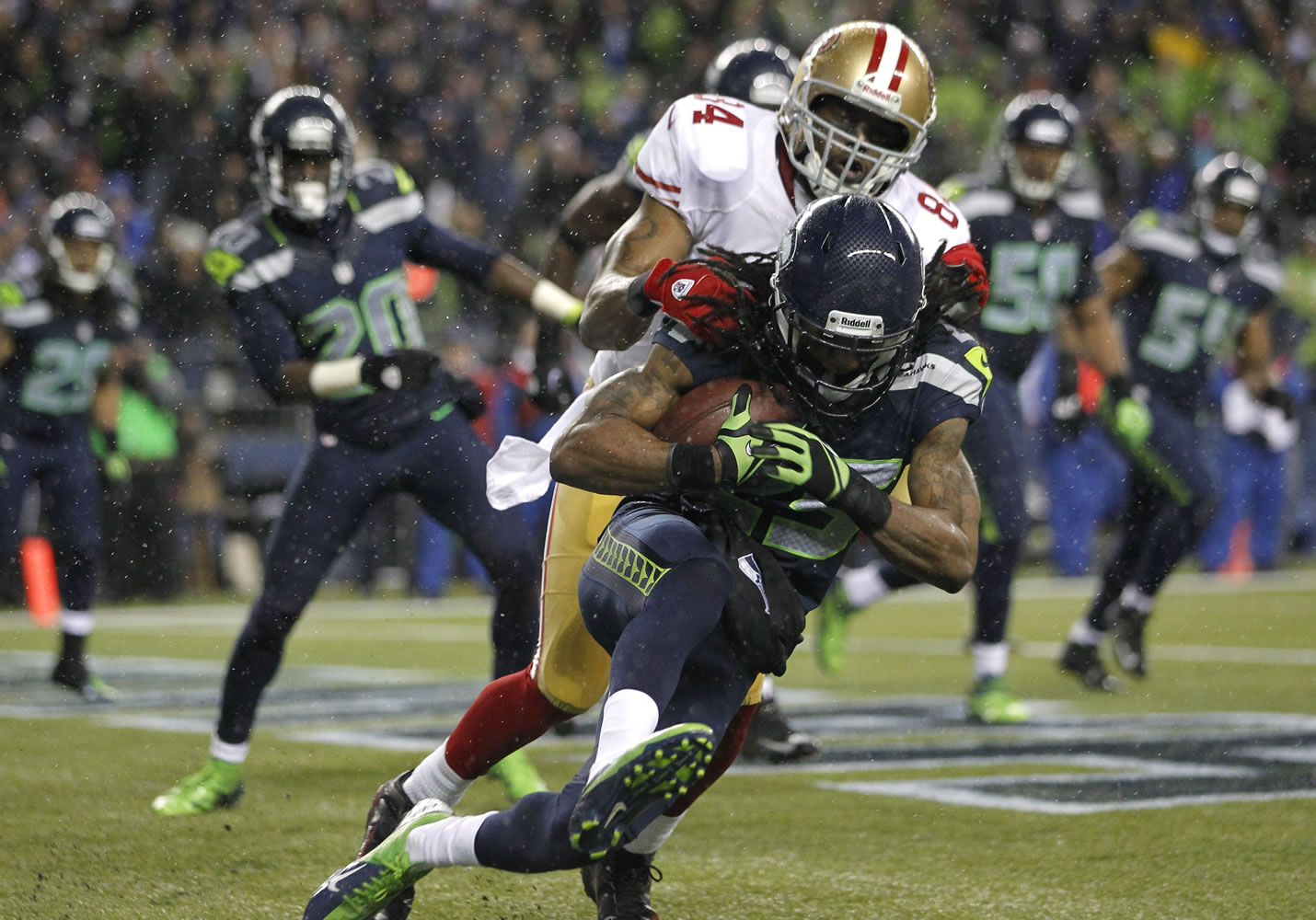 Seattle Seahawks' Richard Sherman comes down with an interception ahead of San Francisco 49ers' wide receiver Randy Moss in the second half Sunday.