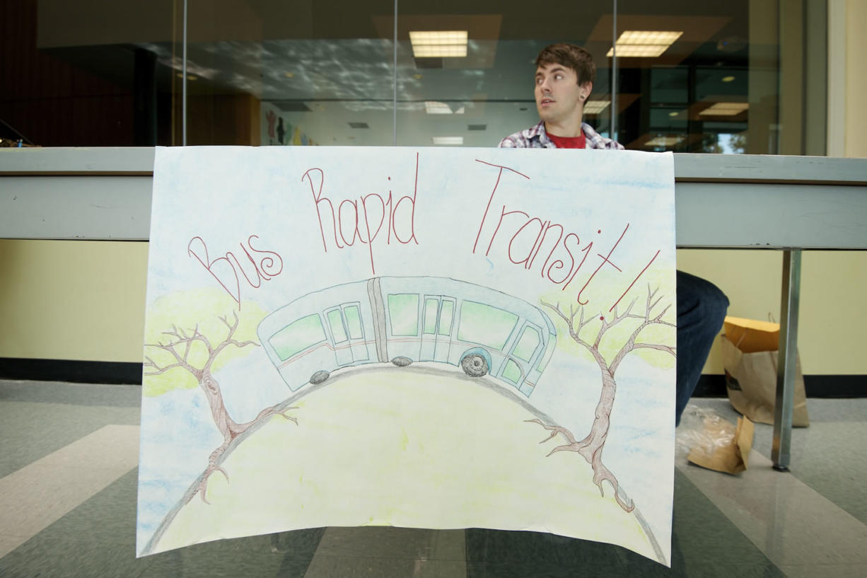 Volunteer Travis Cook sits at a table in support of bus rapid transit last year inside Clark College's Gaiser Hall.