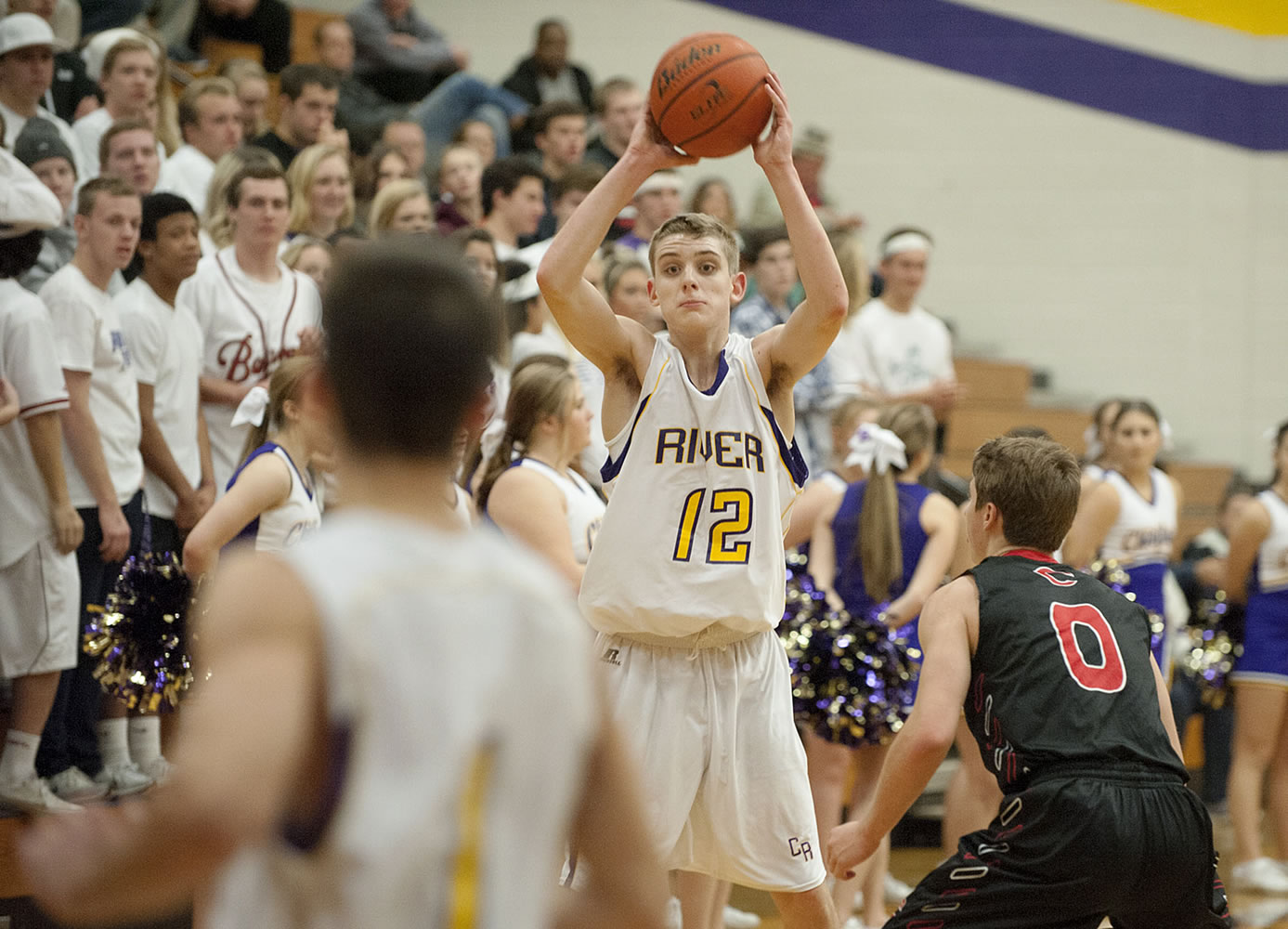 Columbia River&#039;s Jacob Hjort (12) passes to an open teammate past Camas defender Jake Hansel (0) in the second quarter Tuesday night, Dec. 1, 2015 at Columbia River High School gym.