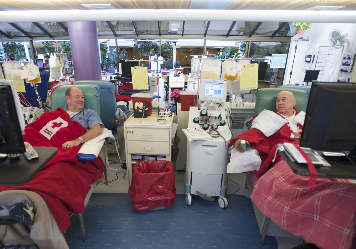 Childhood friends Teddy Peetz, left, and Bill McGinnis donate blood platelets at the American Red Cross Portland Donor Center on Thursday.
