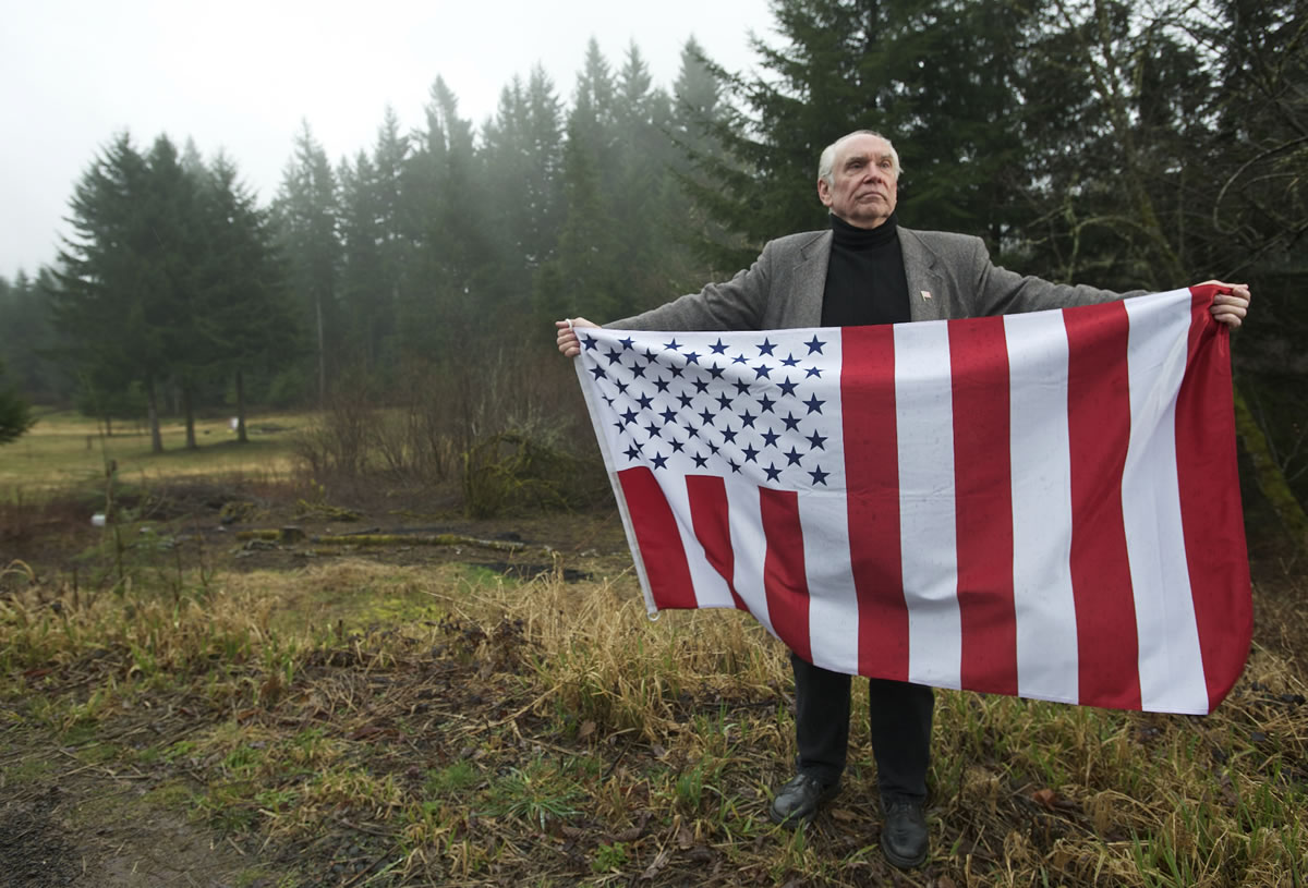 David Darby, a follower of the Sovereign Citizens movement, holds a flag on his Amboy property.