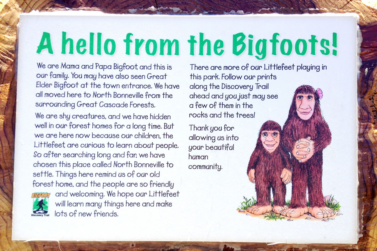A series of wood-carved Bigfoots stands along a trail in North Bonneville.
