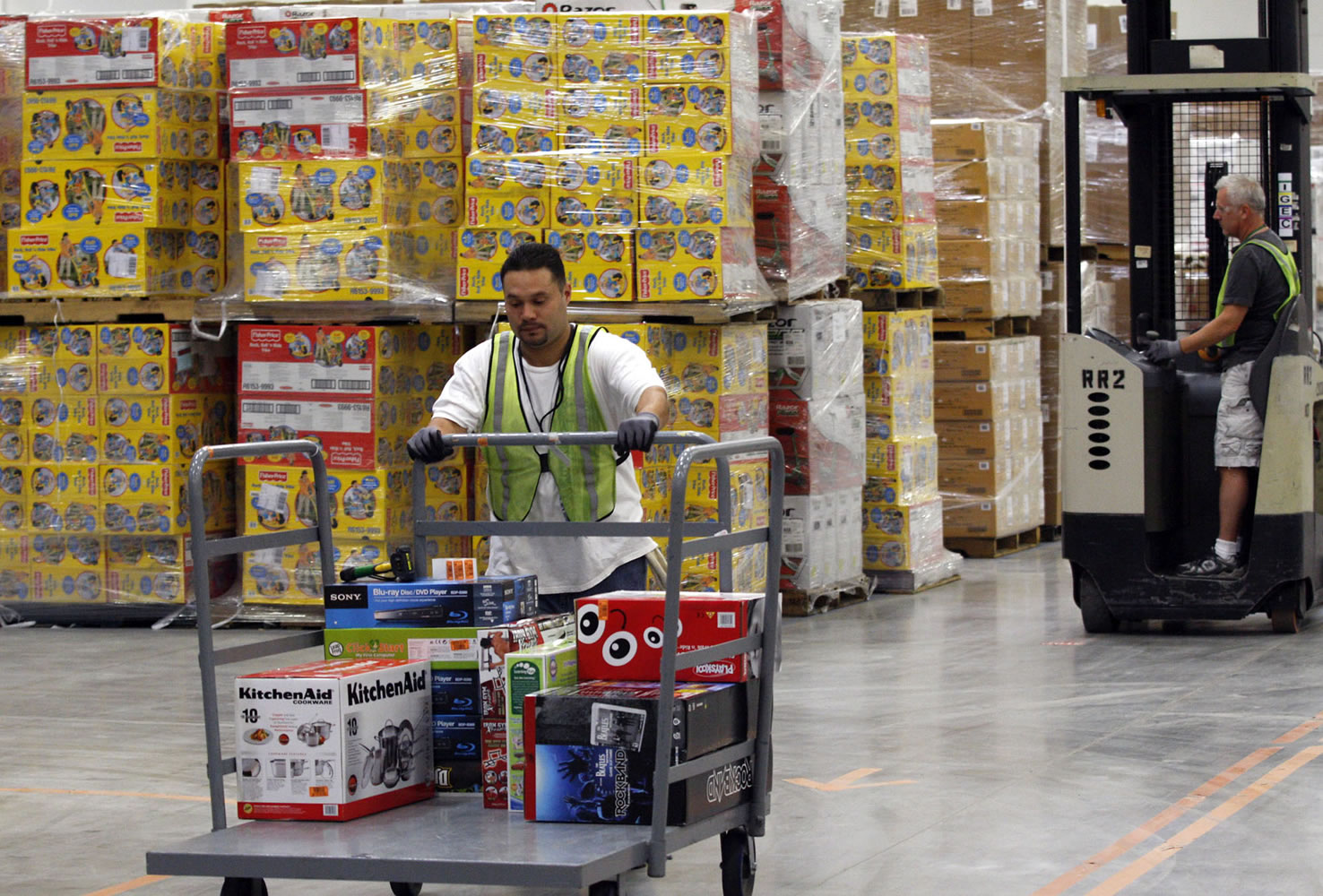 A worker pushes merchandise on a cart at the Amazon.com center in Goodyear, Ariz., in 2009. Walmart's traditional customers, bargain-hunters making less than $50,000 a year, are getting more tech-savvy with Amazon.
