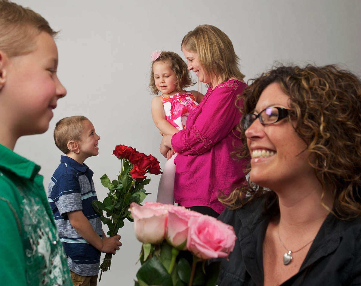 Riley Hays, 5, foreground left, gives his mother, Christa Hays, roses, as does Ryker Loukkula, 5, second from left, to his mom, Emily Loukkula, holding daughter Lucy, 3.