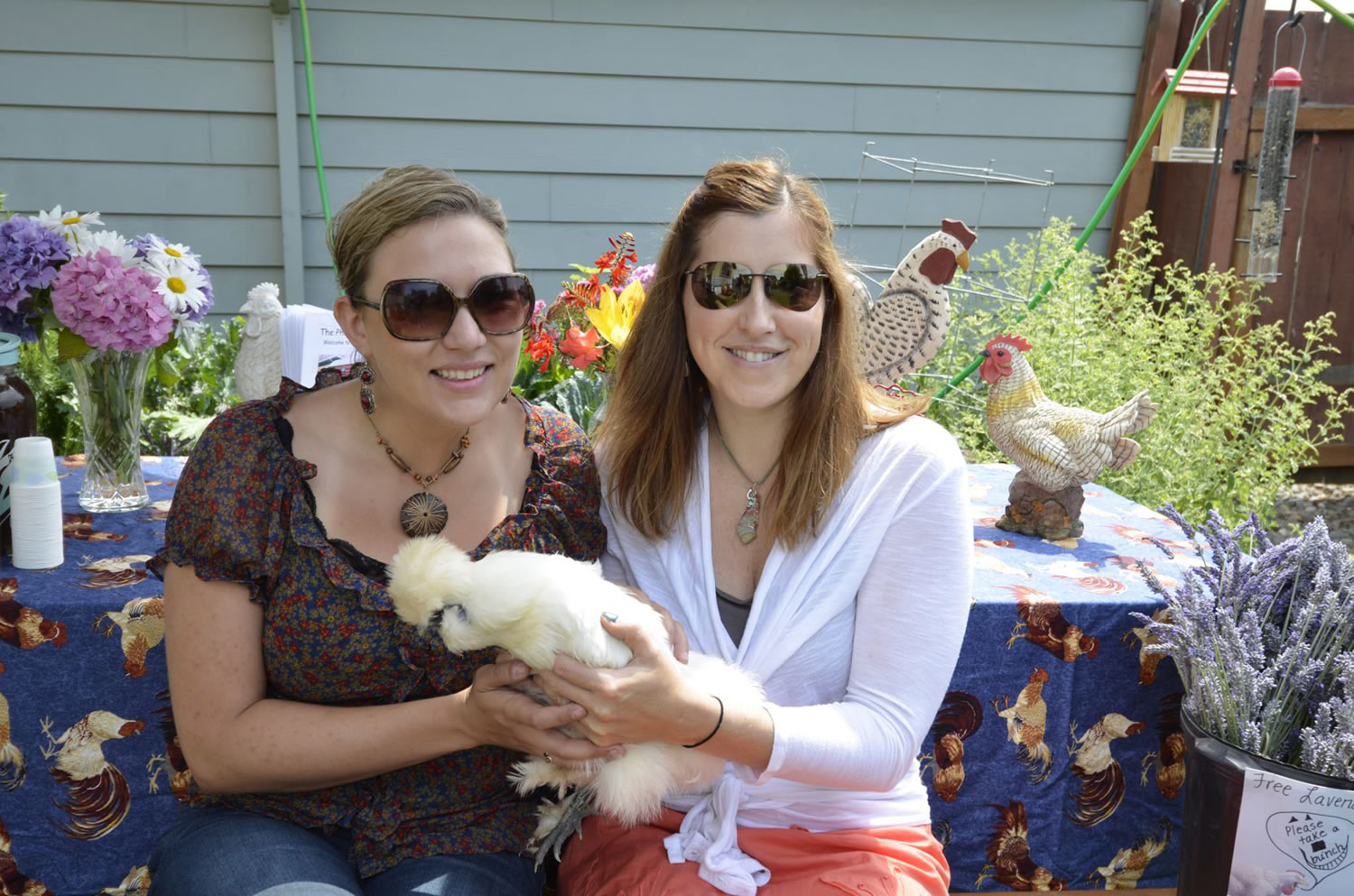 Hough: Volunteers Christina Baldisseri, left and Rachel Clark hold a silky bantam named Dodo at the Coop du Jour Backyard Chicken Coop Tour on July 14.