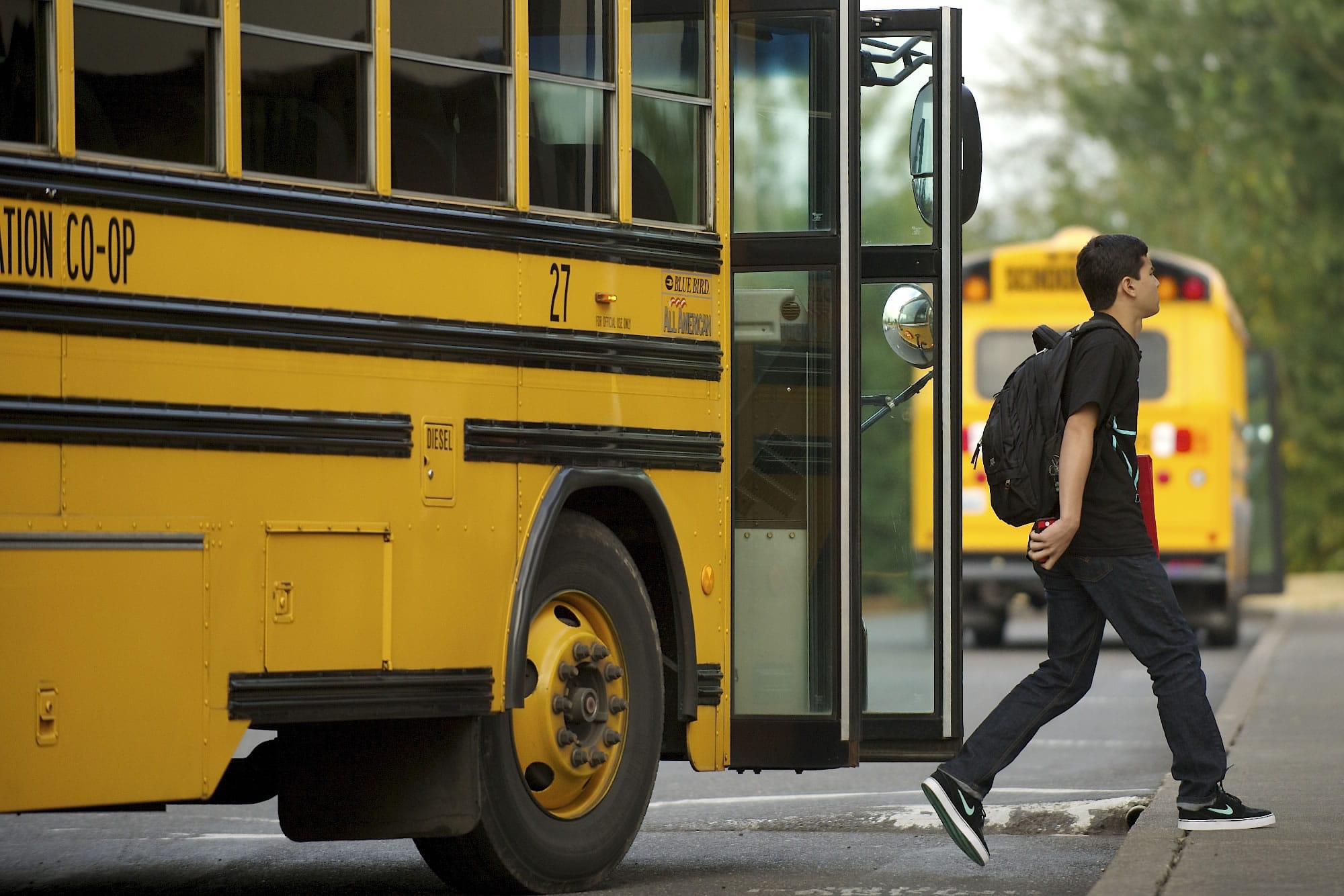 A student at Ridgefield High School disembarks a school bus Wednesday morning, the first day of school.
