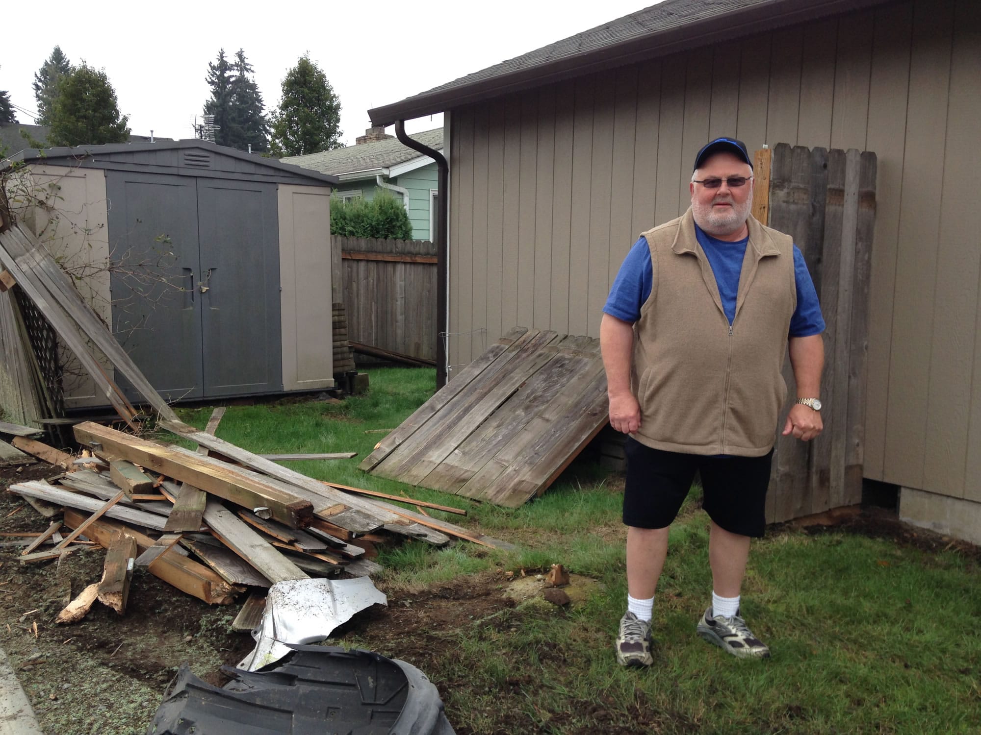Jerry Sutherland stands next to the wreckage of his fence. A car sped through the roundabout at N.E. 32nd Circle on Thursday night and damaged a concrete-moored metal post and fence at his home.