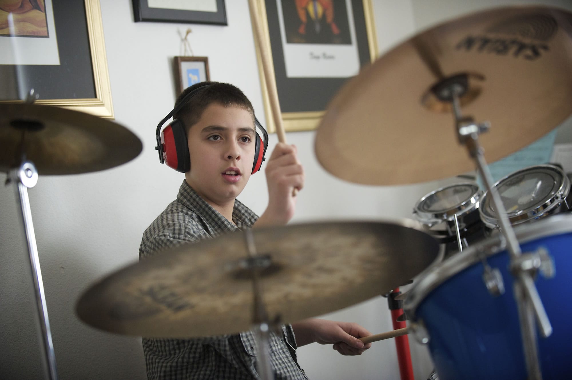 Ian Engelsman, 12, plays the drums in his family's home in Vancouver on Thursday.