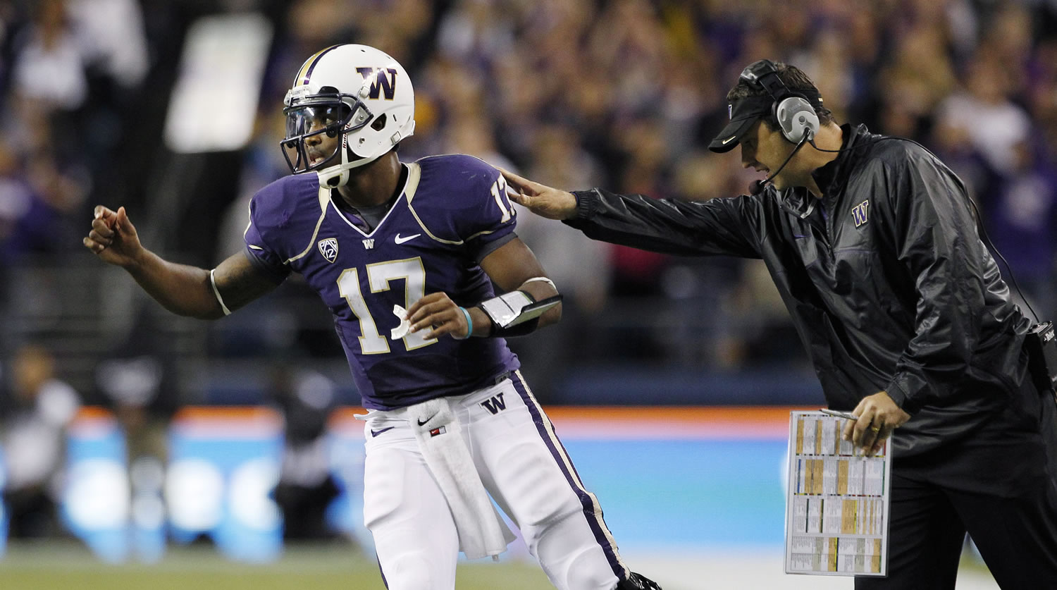 Washington coach Steve Sarkisian, right, gives quarterback Keith Price a pat as Price heads back into the game against Southern California after the two spoke during a break in the second half of an NCAA college football game  Oct.
