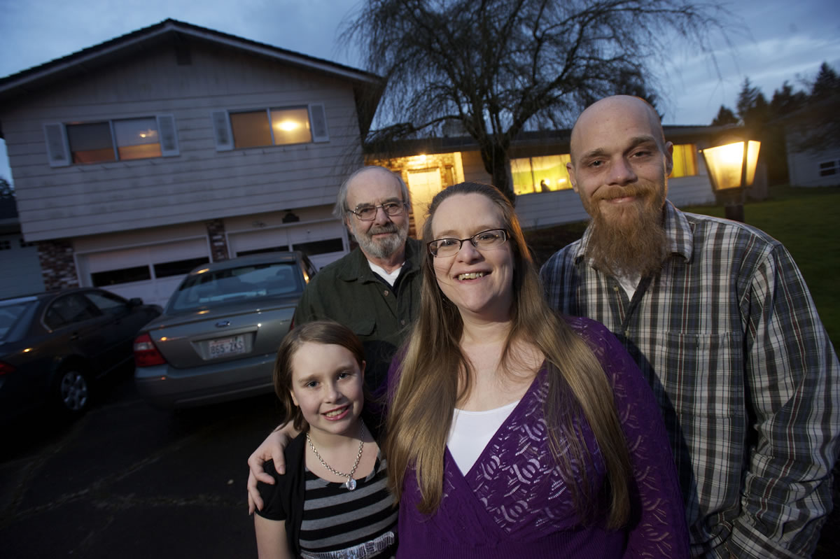 Rebecca Royce, center, gathers her family in front of the Sherwood neighborhood home they purchased last summer thanks to a program that tripled their down-payment savings.
