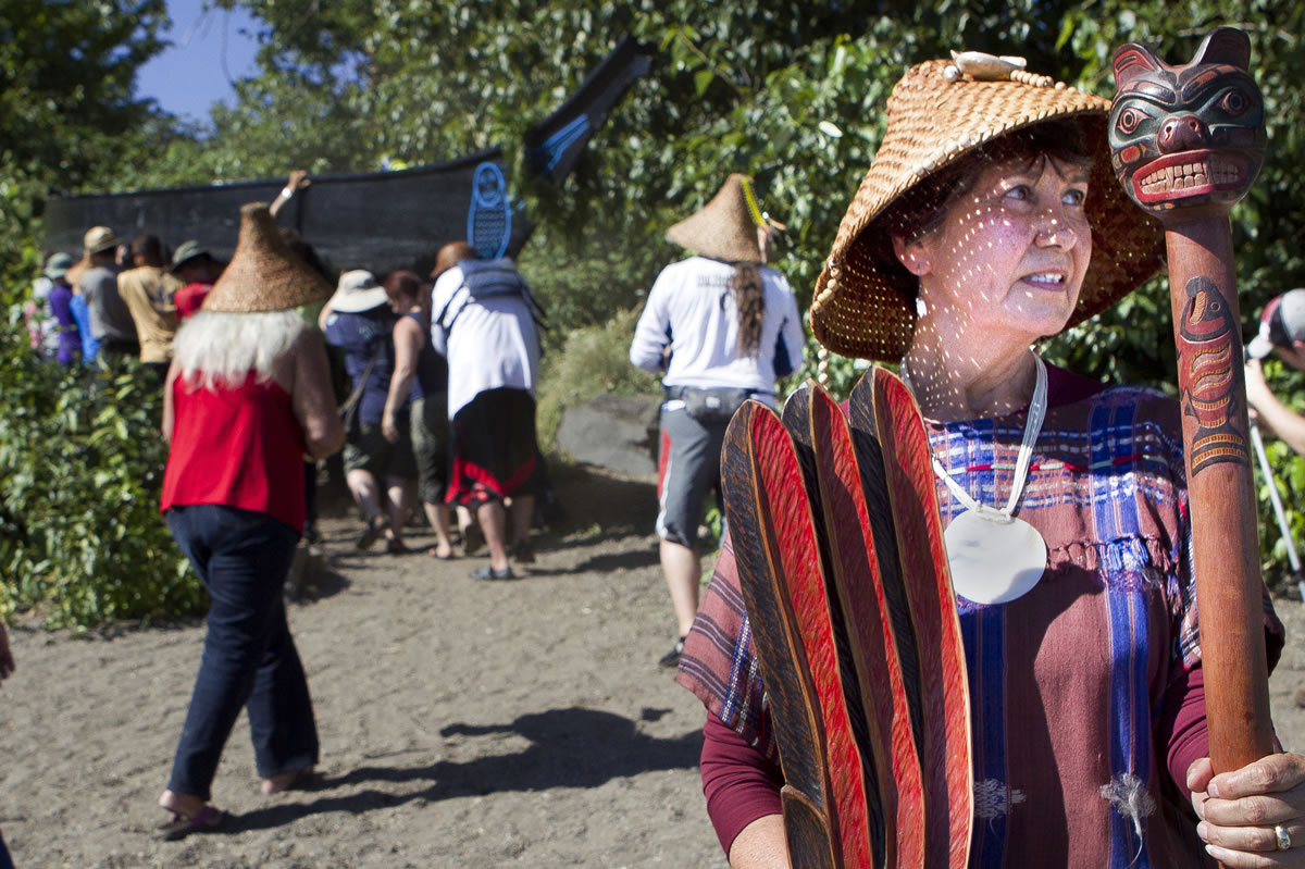 Cowlitz elder Tanna Engdahl presides over the ceremony as three canoes are carried from the Columbia River for an overnight encampment at Fort Vancouver National Historic Site.