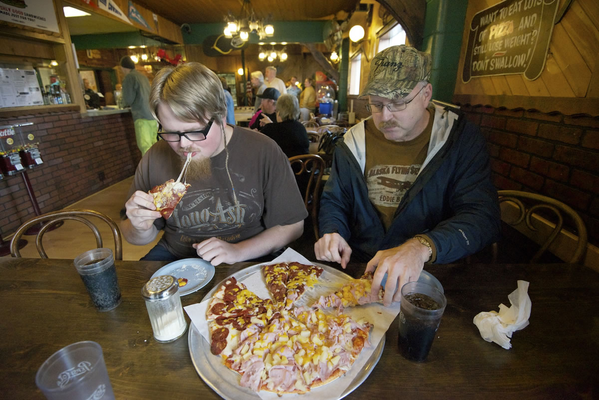 Nathan Burton, left, and his father, Bradley Burton, enjoy lunch at Smokey's Pizza on Monday, the restaurant's final day of business.