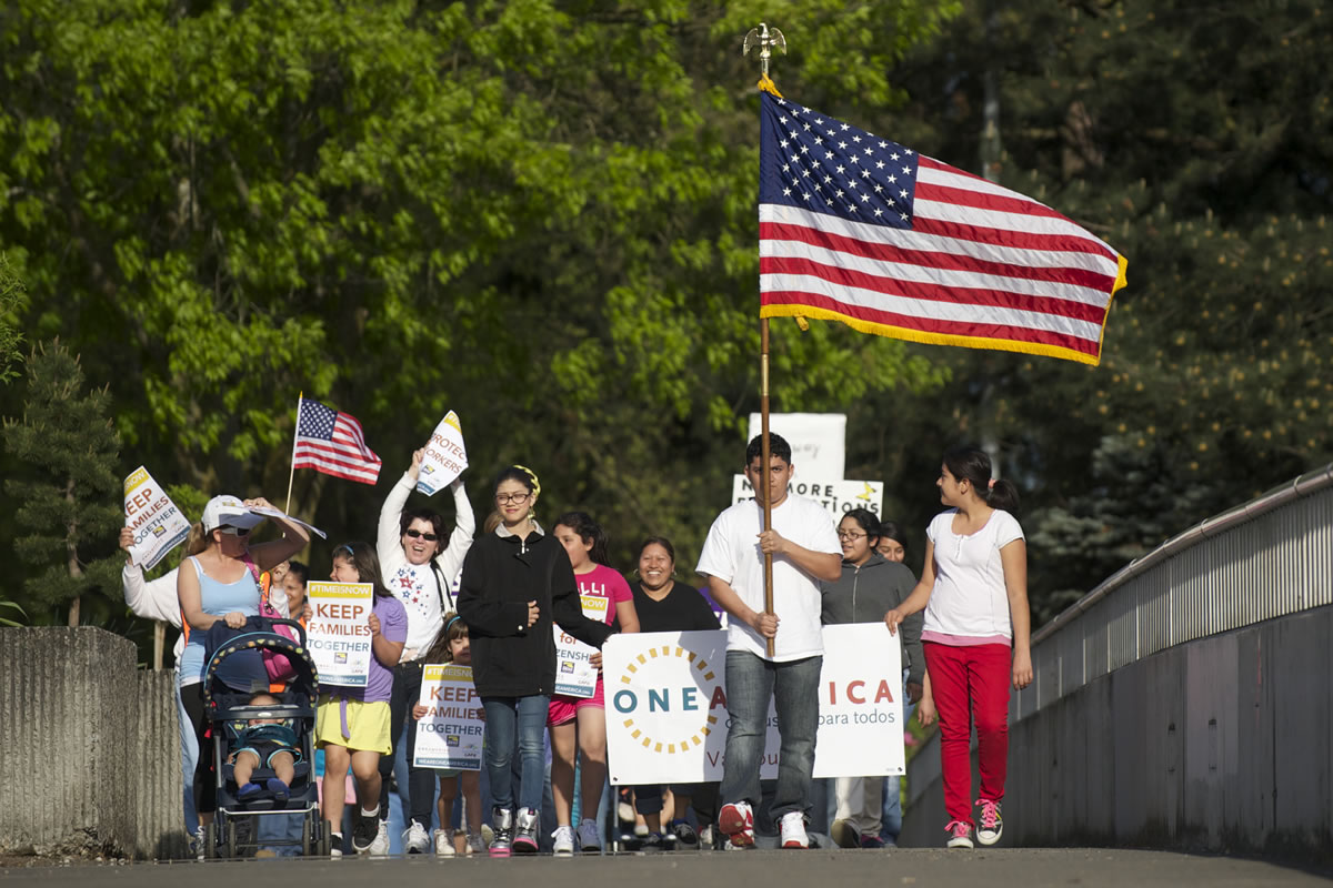 A group of immigration reform supporters marches Wednesday from U.S. Rep. Jaime Herrera Beutler's Vancouver office at the O.O.