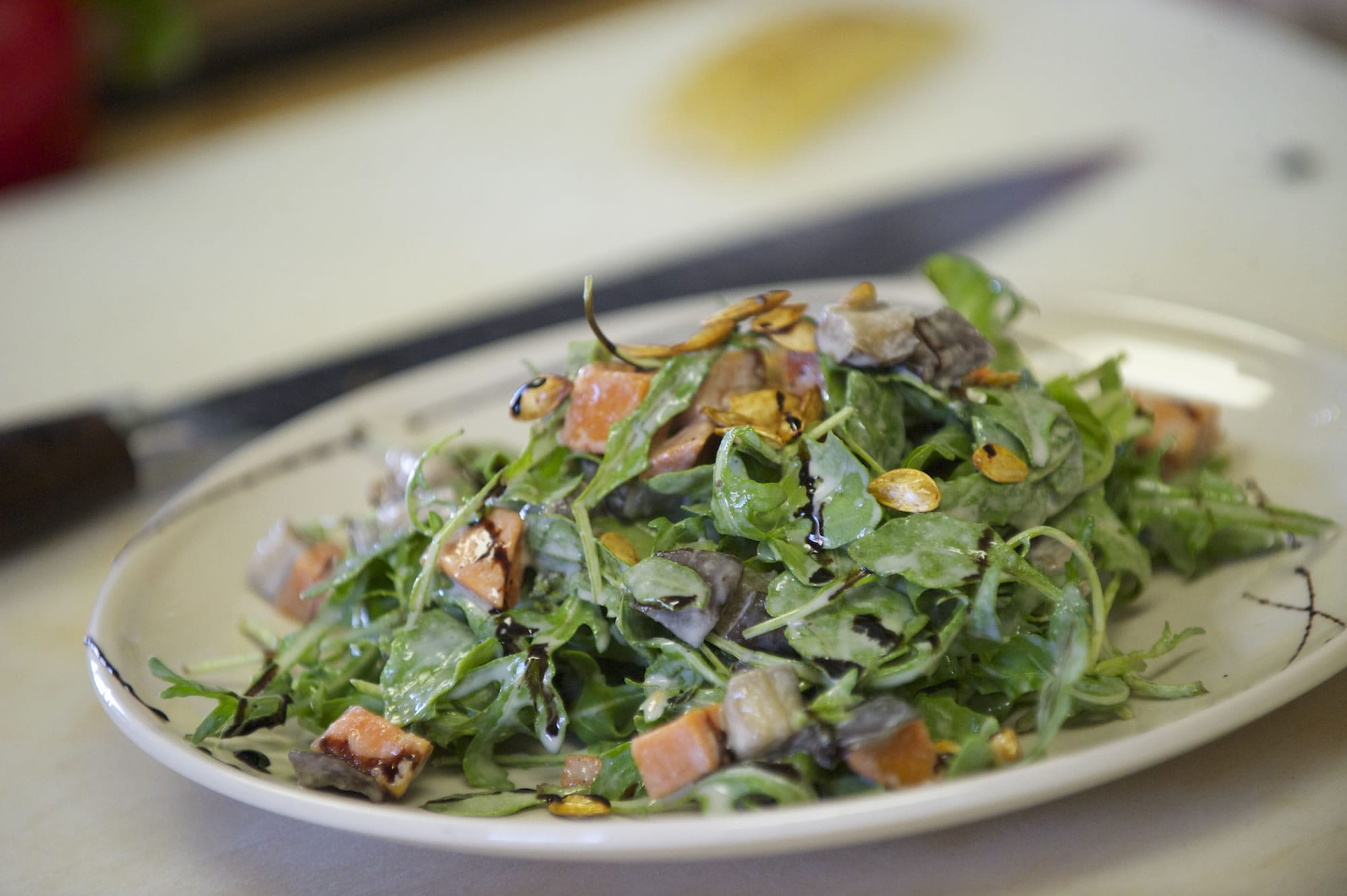 A Mint Tea salad special of arugula, yam and eggplant tossed in a tahini vinaigrette and topped with pumpkin seeds is ready for a customer at the restaurant Thursday.