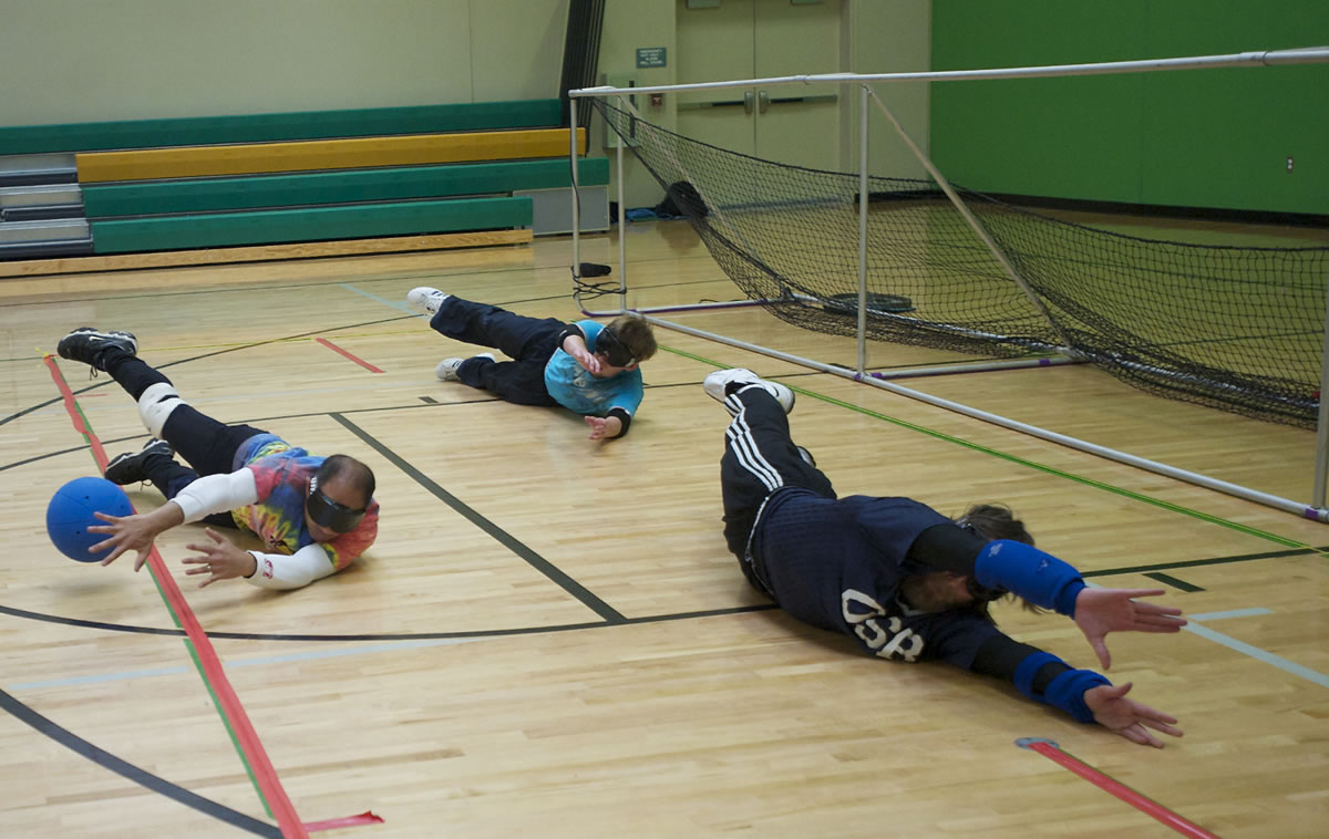 Nov Gnik, left, and his teammates drop to their sides and block a shot during goalball practice at the Washington State School for the Blind on Monday. The group is getting ready for the 2013 National Goalball Championship tournament, to be held at McLoughline Middle School Thursday through Saturday.