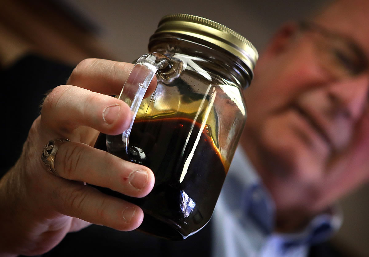 Williston, North Dakota Mayor E. Ward Koeser displays a jar containing Bakken crude oil, May 2, 2013.