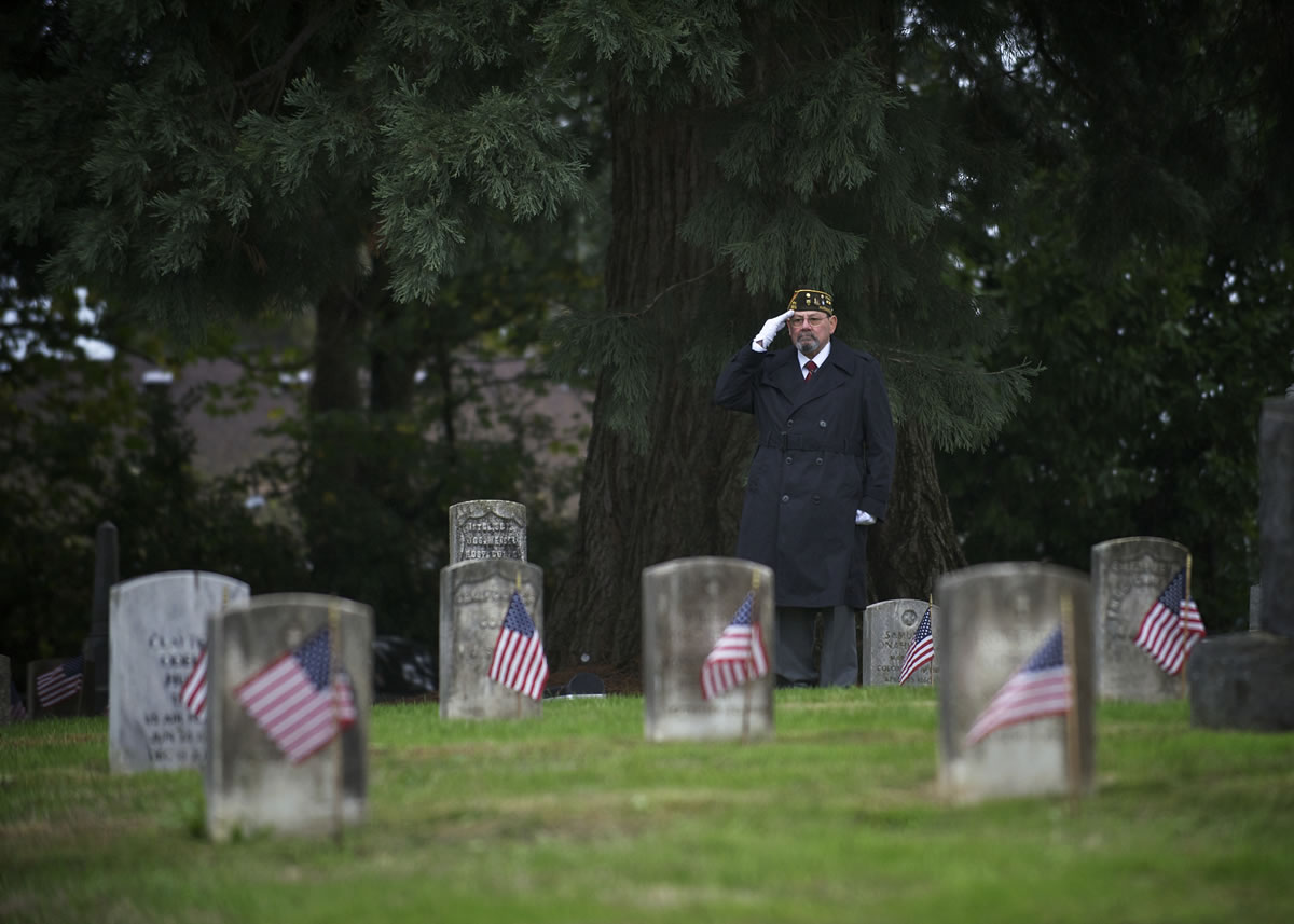 Bugle player Richard Alvarez salutes as Vancouver observes Veterans Day during a ceremony at the Vancouver Barracks Post Cemetery on Sunday.