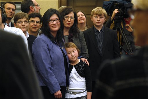 Heather Kawamoto, center left, and her partner Kay Lancaster stand with their daughter, Kayleigh Kawamoto, 9, during a signing ceremony for Referendum 74 on Wednesday. Gay couples can marry beginning Sunday.