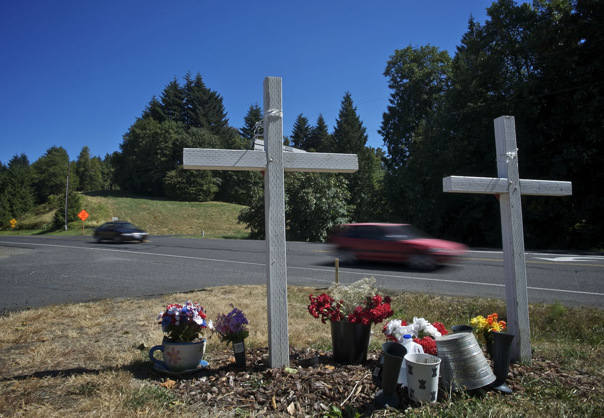 Traffic rolls past a memorial for Karey Brown and Steven Dodd on Northwest La Center Road near Northwest Eagle Crest Drive.