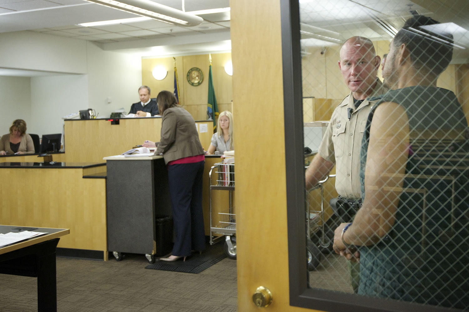 Clark County sheriff's custody officer Vaughn Gano calls an inmate from a secure area during a Superior Court session on Monday at the Clark County Courthouse.