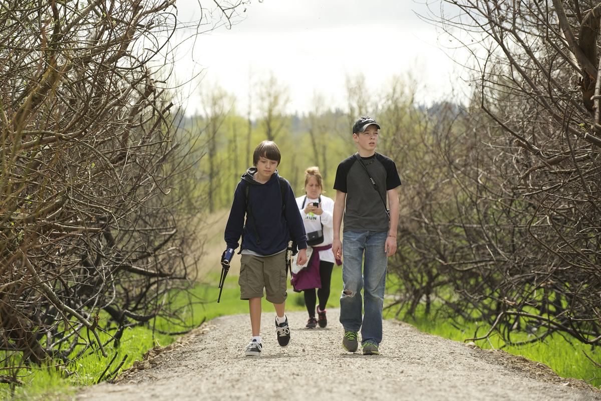 Birdwatching buddies Garret Foster, 14, left, and Noah Bumala, 12, with Garret's mom, Jill Foster, following, walk a section of trail at the Steigerwald Lake National Wildlife Refuge on Tuesday. The trail reopened last week after a fire burned nearly 150 acres of habitat in October.