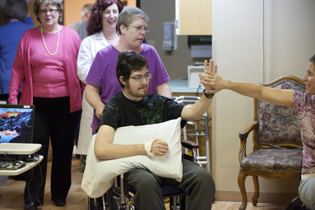 Joseph Reilly high-fives physical therapy assistant Shannon Nelson a day before he is to be released from the Fort Vancouver Convalescent Center.