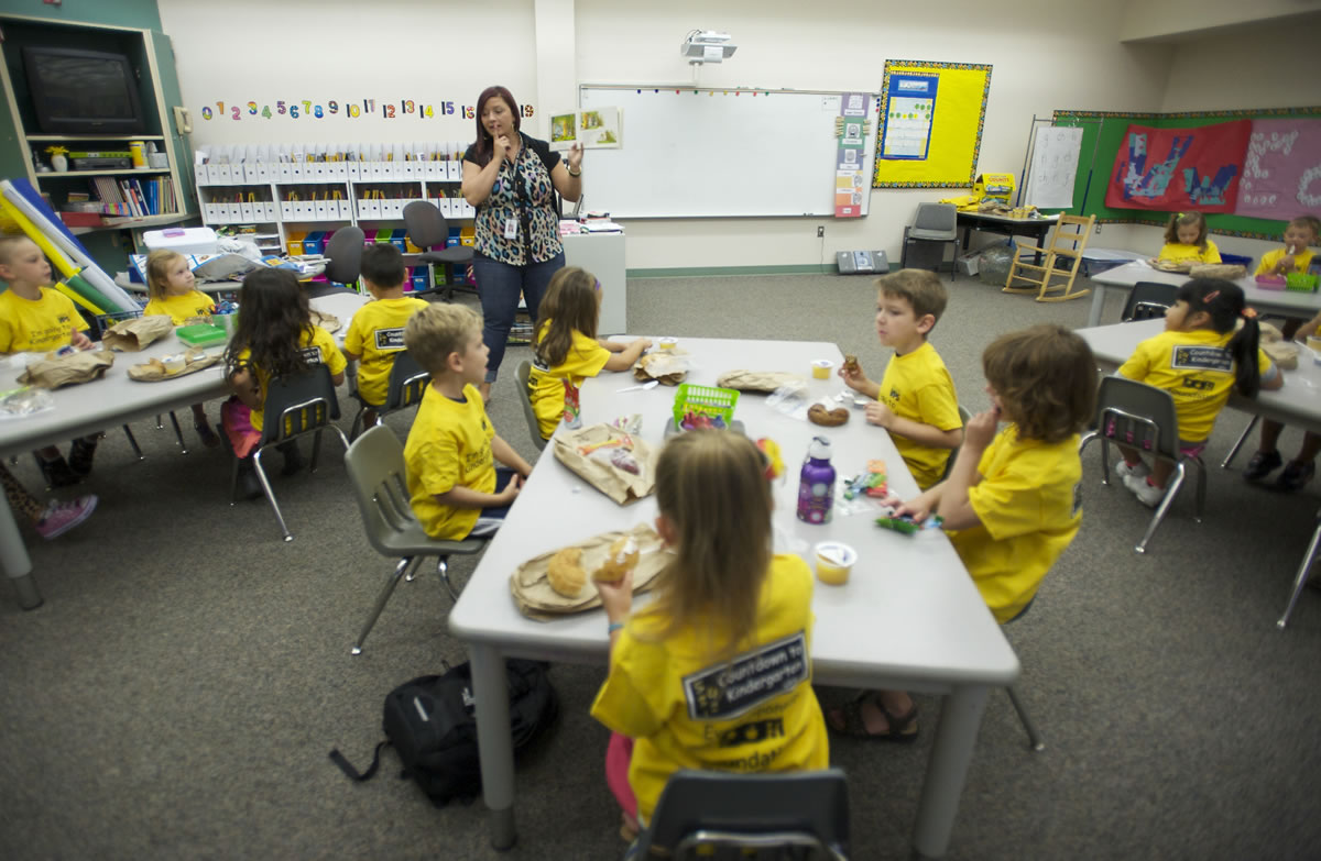 Renee Sutter reads to her kindergarten class during snack time at Harney Elementary School on Thursday.