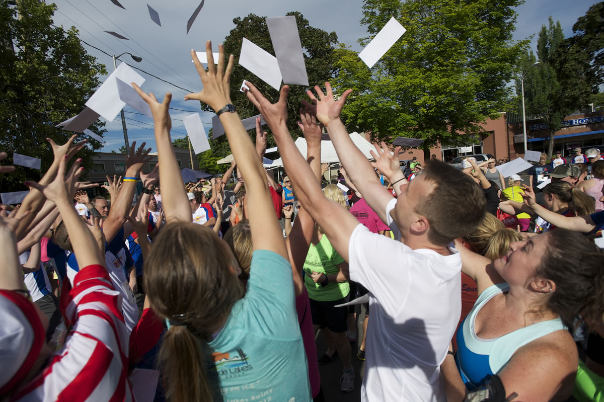 Runners reach for envelopes containing challenges and clues to complete the Summer Solstice Fun Run on Saturday in downtown Vancouver.