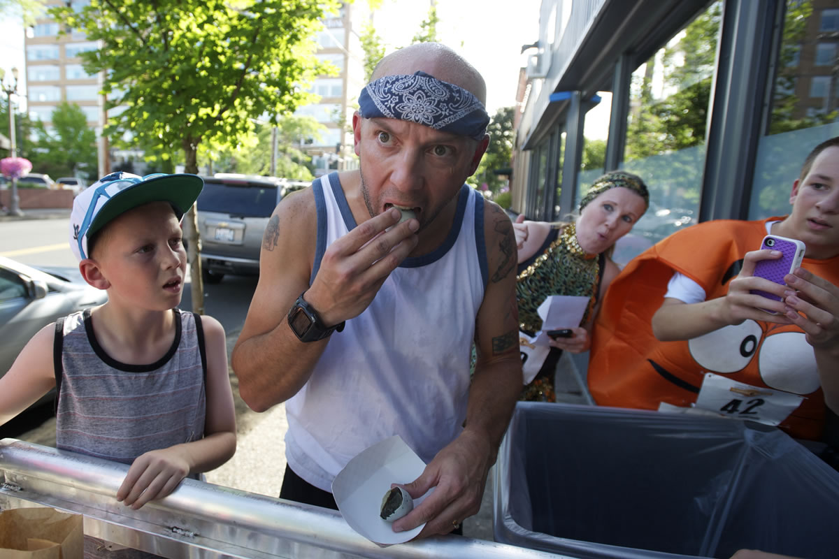 Robby Halterman eats a 100 year old preserved duck egg during a challenge at The Main Event as part of the Summer Solstice Fun Run, Saturday, June 22, 2013. Teams that did not eat the century egg were penalized 5 minutes.