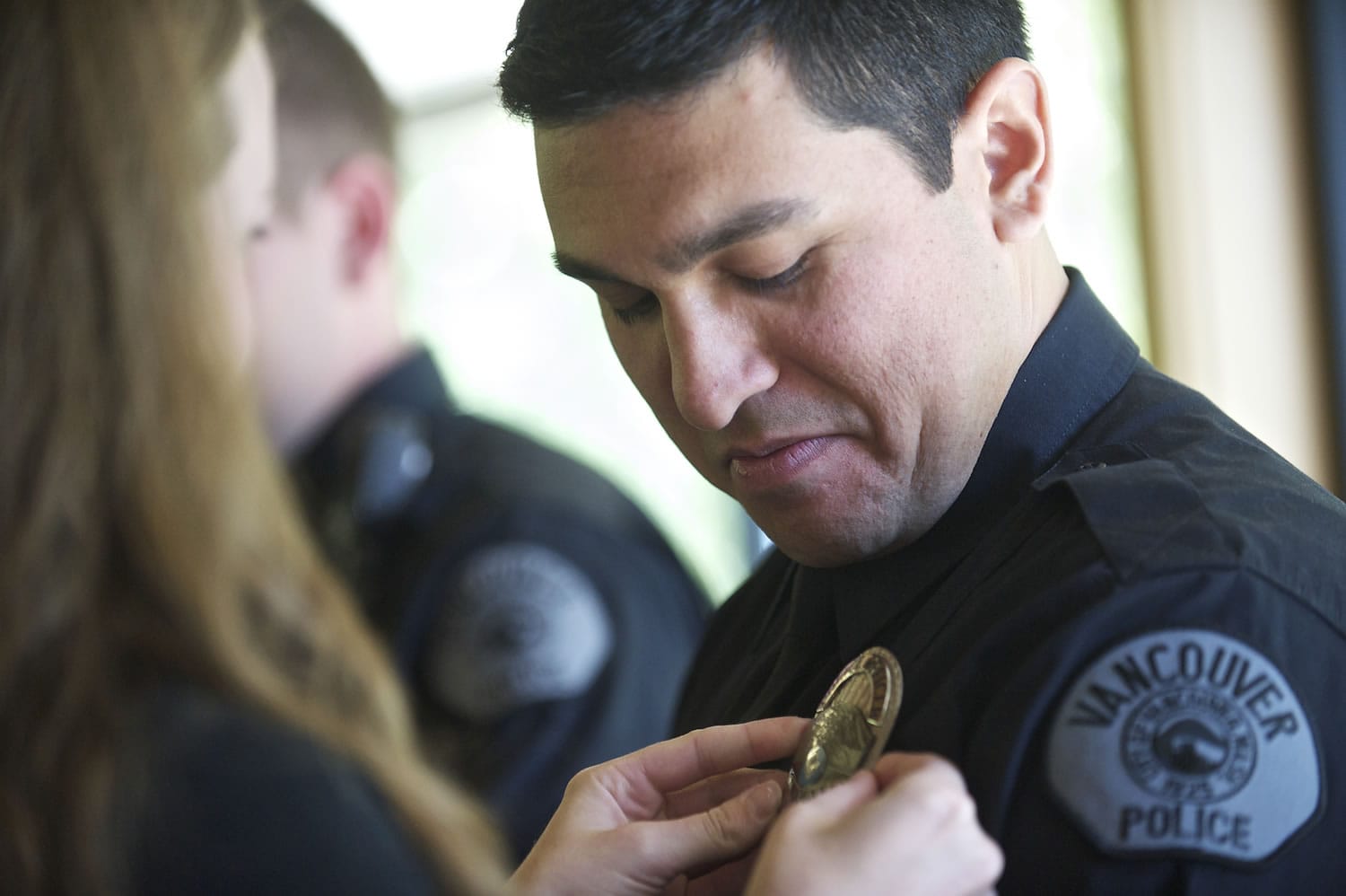 Ellen Kilmer pins his badge on her boyfriend, new Vancouver Police officer Carlos Urquiza, after he was sworn in July 25.