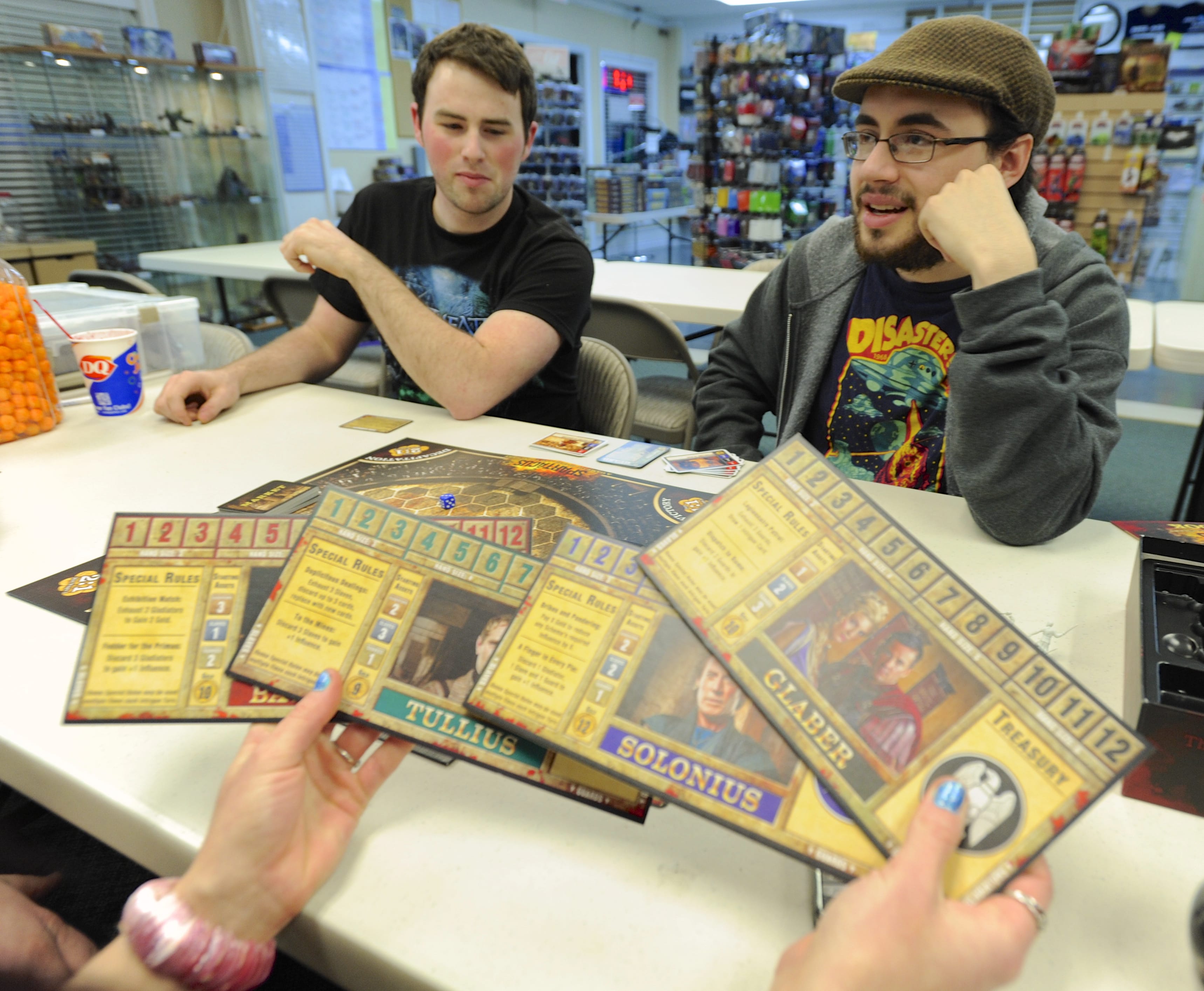 Board gamer Seaton Bryan, right, explains the rules of Spartacus to other players, including Robert Wood on March 15 at the Dice Age store in Vancouver.