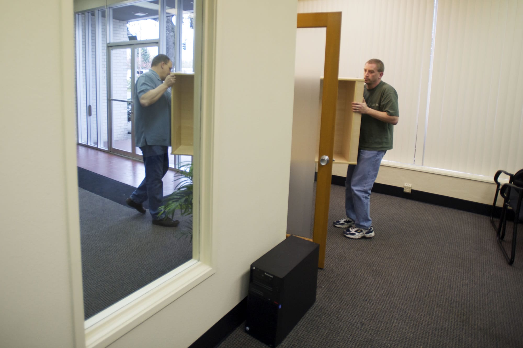 ITPro general manager Bob Berry, left, and tech manager Terry Meisner move furniture into the company's new office Monday.