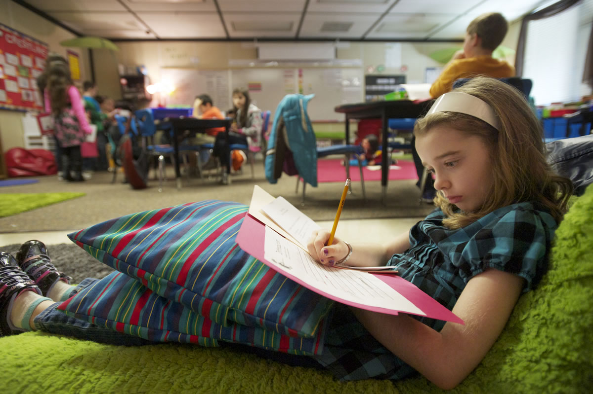 Brittney Meyer, 8, a Crestline Elementary third-grader, works on her essay titled &quot;Dash is a Good Puppy&quot; in her new classroom at Riverview Elementary.