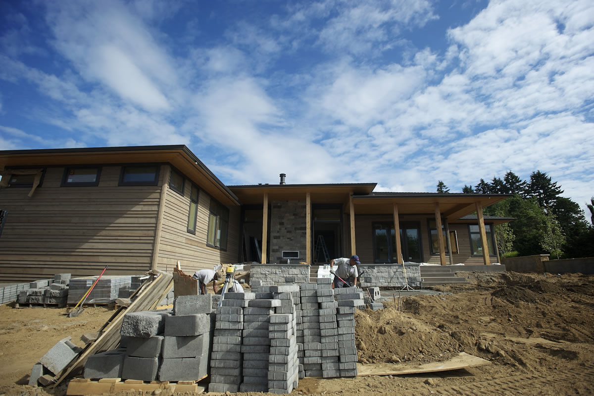 Work continues outside &quot;The Odyssey,&quot; one of four homes to be showcased starting Friday at the NW Natural Parade of Homes at Evergreen Pointe, a development near the Columbia River in Vancouver.