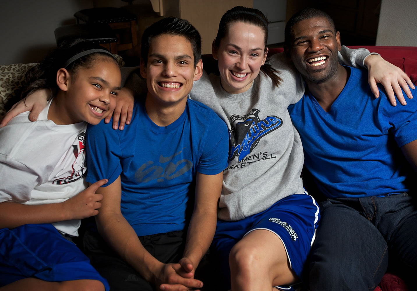 Clark College basketball player Tanya Martin sits with her husband Eugene Martin, right, and daughter Jaydia, 9, and nephew Michael Chavez, 16, to whom the Martins serve as his legal guardian.
