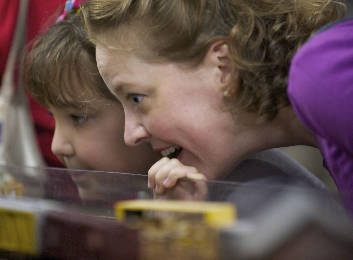 Elizabeth Castanon of Vancouver and her daughter, Adriana, 10, get a closer look at a passing train during the Southwest Washington Model Railroaders open house at their clubhouse on Saturday.