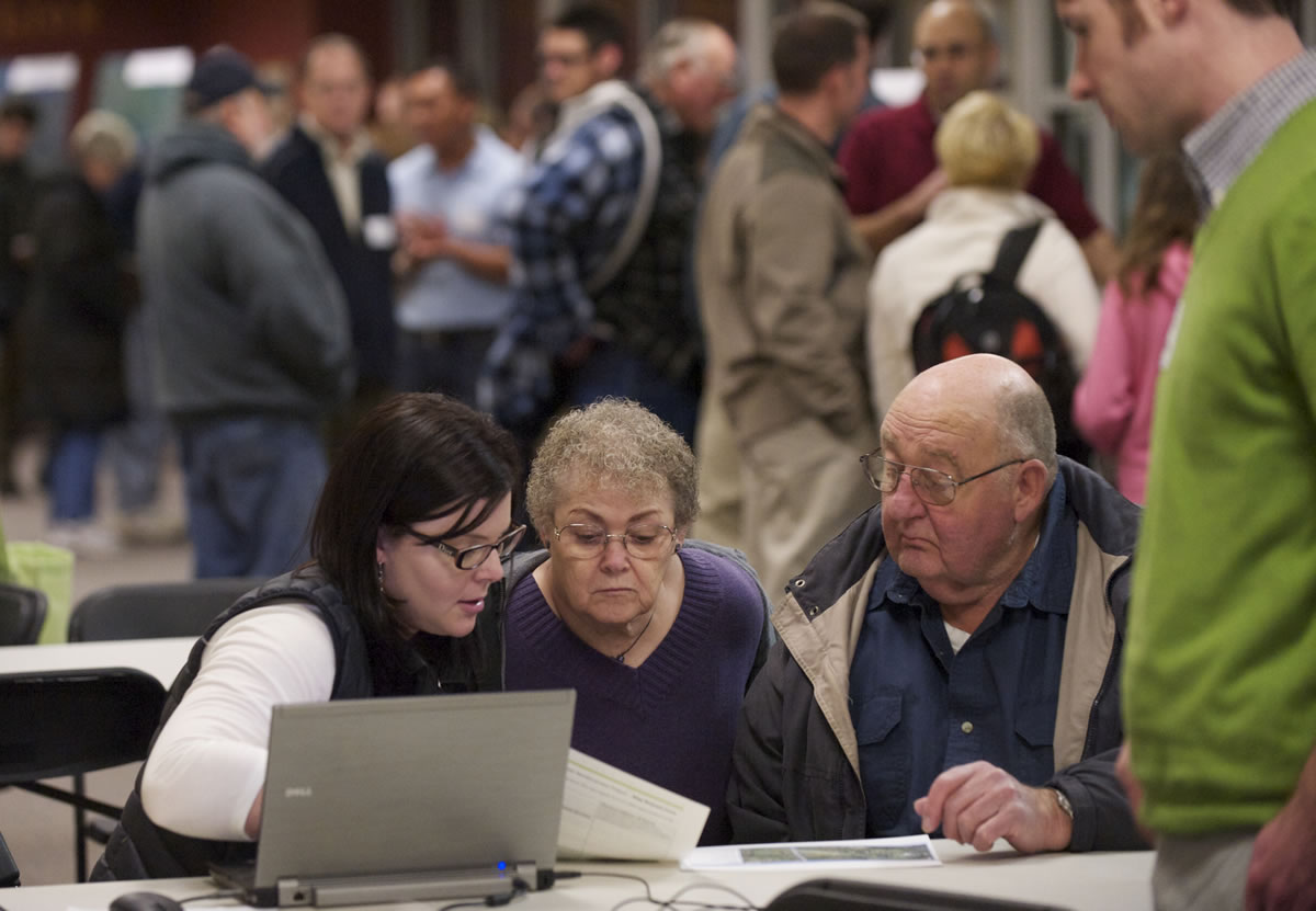 Landowners John and JoAnn Michel, center and right, look at an interactive map with Bonneville Power Administration consultant Katy Fulton during an open house meeting in Camas on Tuesday.