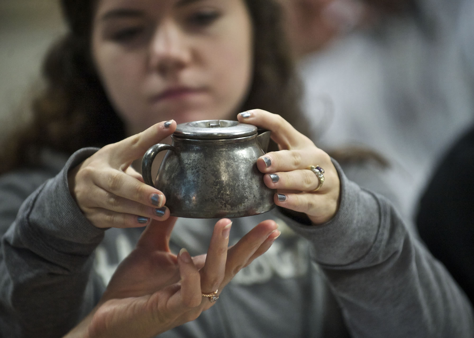 Heritage High School student Darlina Rose, 16, examines a 70-year-old creamer that contained a World War II-era telegram announcing the death of fighter pilot 2nd Lt.