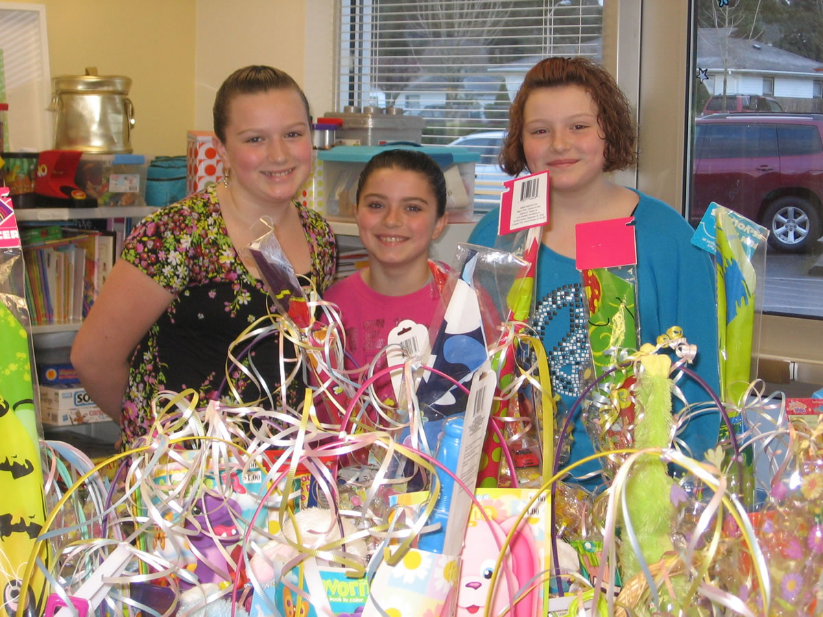 Fruit Valley: Allyson Tindall, from left, Lillyan Tindall and Chloe Huebner finish up packing Easter baskets for families in need.