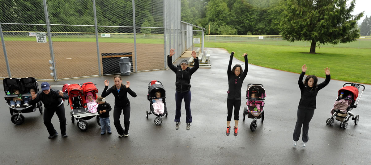 Personal trainer Kim Puyleart, second from right, leads participants in her Vancouver Mommy Fitness Playgroup through an exercise at Hockinson Meadows Park in Hockinson on Tuesday.
