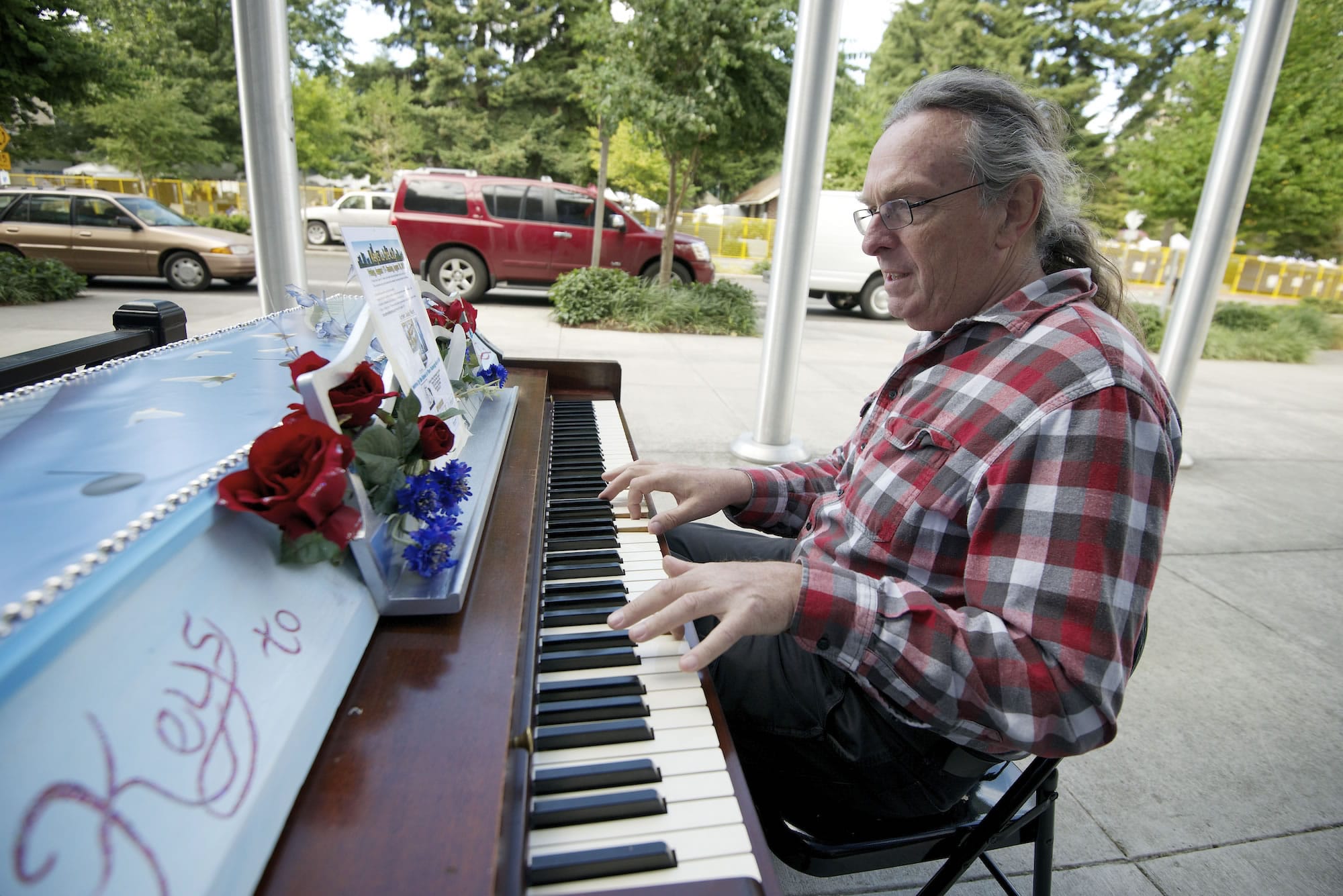 Dezy Walls, a musician and playwright from Carlton, Ore., performs &quot;Write Myself a Ltter&quot; on a painted Aerosonic Baldwin piano outside Vancouver City Hall.
