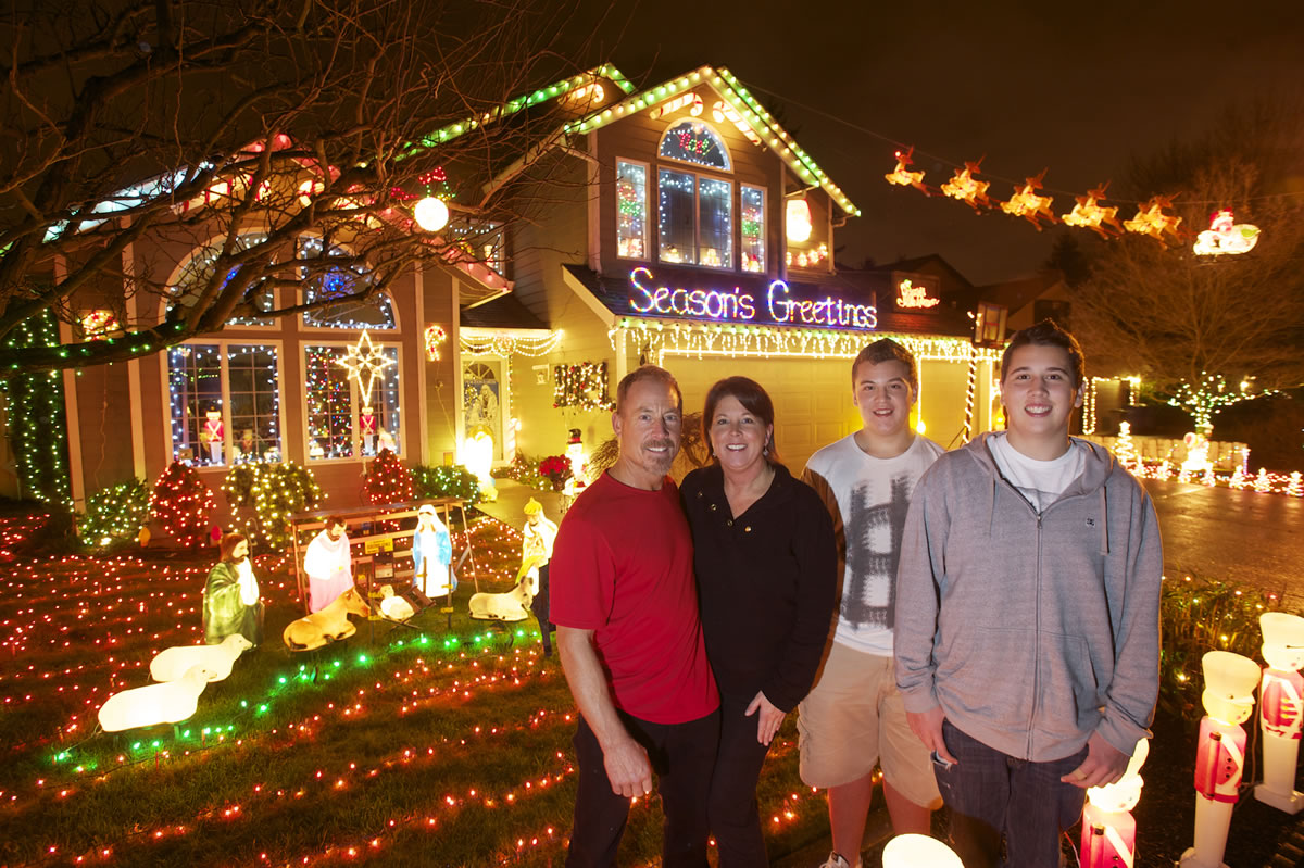 The Buchanan family, from left, Brad, Brenda, Brant, 15, and Bryce, 17, show off their Christmas light display.