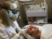 Jane Dudik, owner of Acne Treatment Center in Vancouver, works on client Brennan Dyehouse, 16.