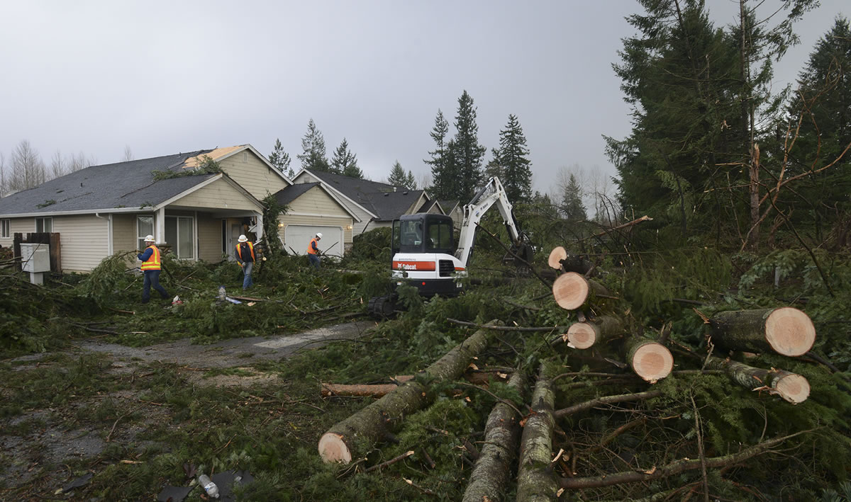 A crew from Battle Ground Public Works clears the aftermath of a tornado that tore through the city at about 11:15 a.m. Thursday, uprooting trees and damaging homes and power lines.
