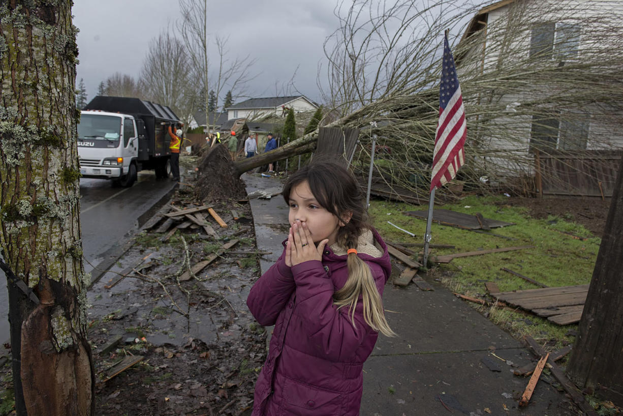 Battle Ground resident Bela Morgan, 9, reacts to seeing damage and debris left by a tornado along Southeast Rasmussen Boulevard. She viewed the aftermath, including a knife stuck in a tree, Thursday afternoon with her family.