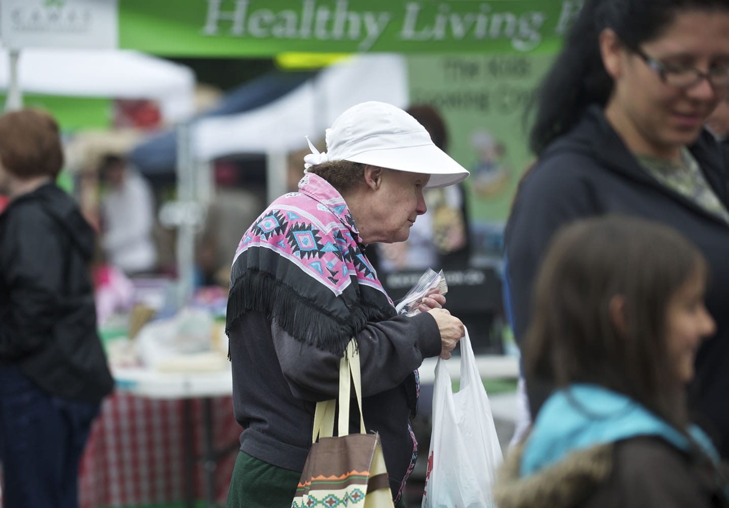 SNAP client Marie Mueller, 62, of Camas carries a bag of fruit and fresh bread she bought Wednesday at the Camas Farmer's Market.