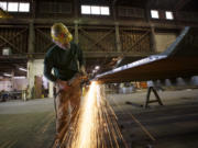 Lee Olds grinds steel channels to be used in a parking structure.