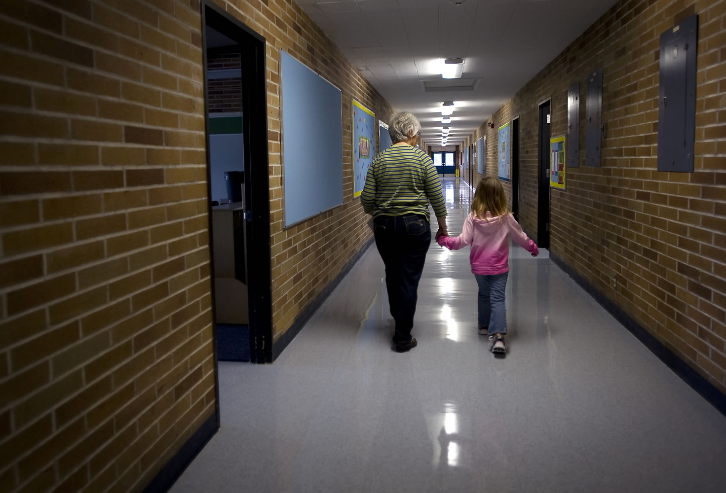 Staff assistant Sharleen Smith escorts a student to her first grade class at Ellsworth Elementary School in 2011.