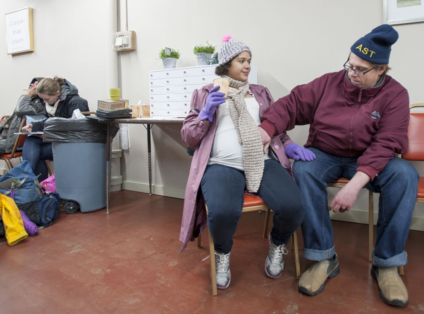Jay Bohn strokes fiancee Lydia Lane's baby bump Tuesday as they relax at Vancouver's new day center for the homeless at Friends of the Carpenter. The couple, who are expecting a baby in March, said they got engaged Monday.